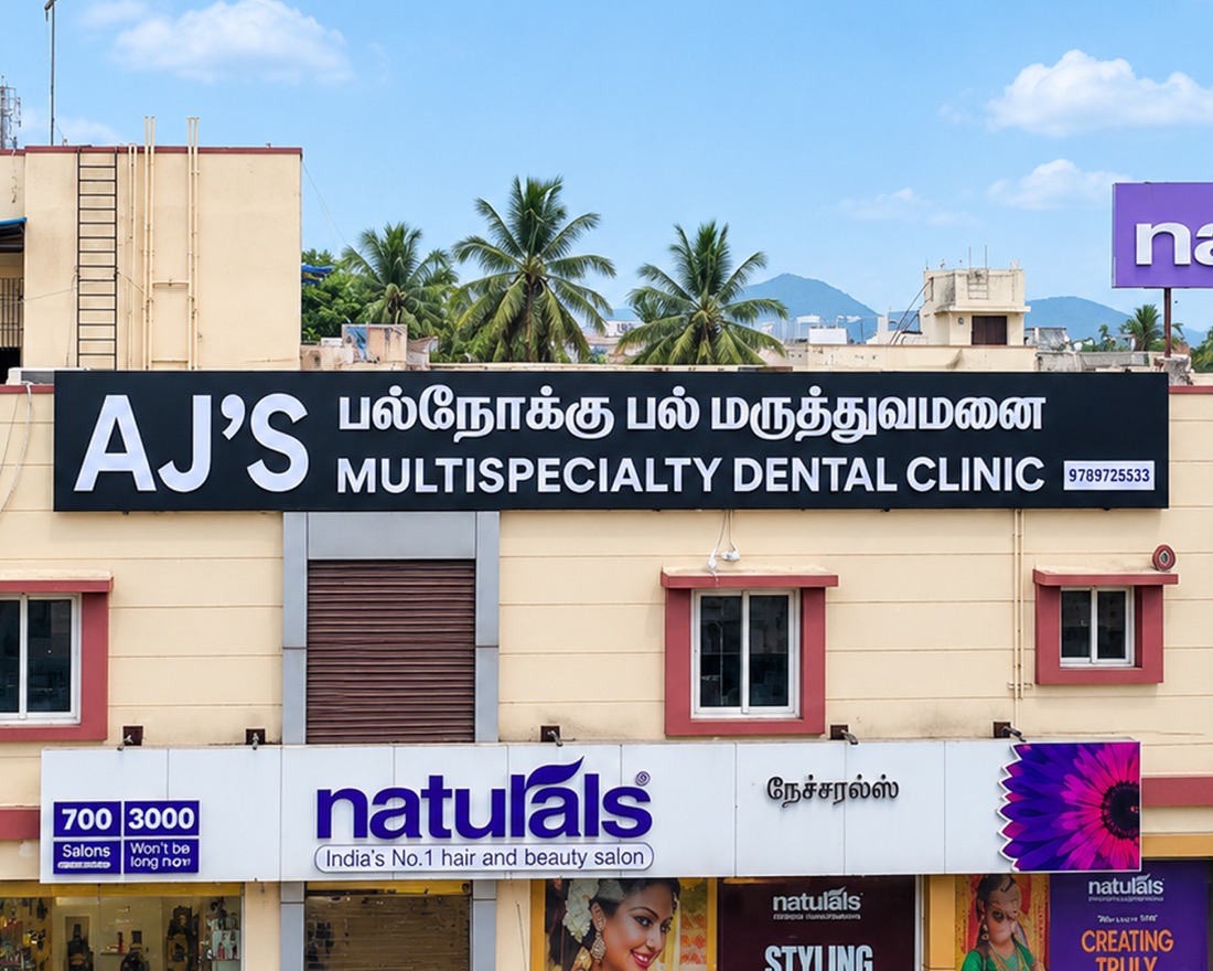 AJ's Multispeciality Dental Clinic signage above the Naturals salon on Mudichur Road